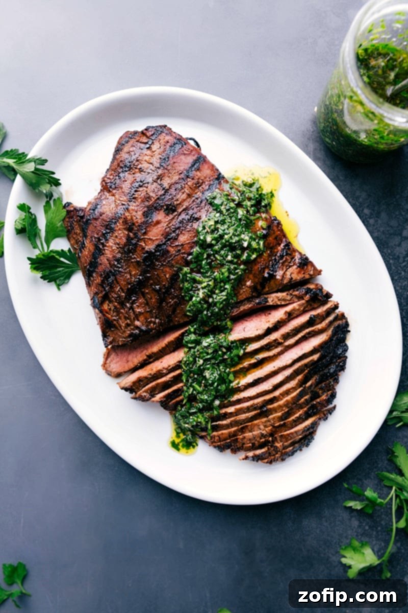 Mouthwatering Grilled Flank Steak with Chimichurri Sauce A sizzling grilled flank steak with a drizzle of vibrant chimichurri sauce on top, garnished with fresh herbs.