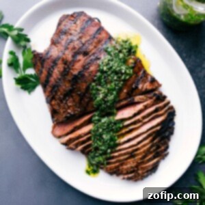 Perfectly Grilled Flank Steak 5 A sizzling grilled flank steak with a drizzle of vibrant chimichurri sauce on top.