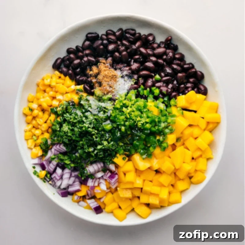 How To Make Mango Black Bean Salsa All diced ingredients for Mango Black Bean Salsa combined in a large mixing bowl, showcasing the blend of colors and textures before a gentle toss.