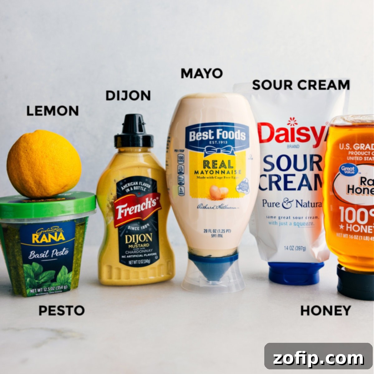 An array of fresh, vibrant ingredients for pesto chicken salad dressing, beautifully arranged on a clean countertop, ready for preparation.