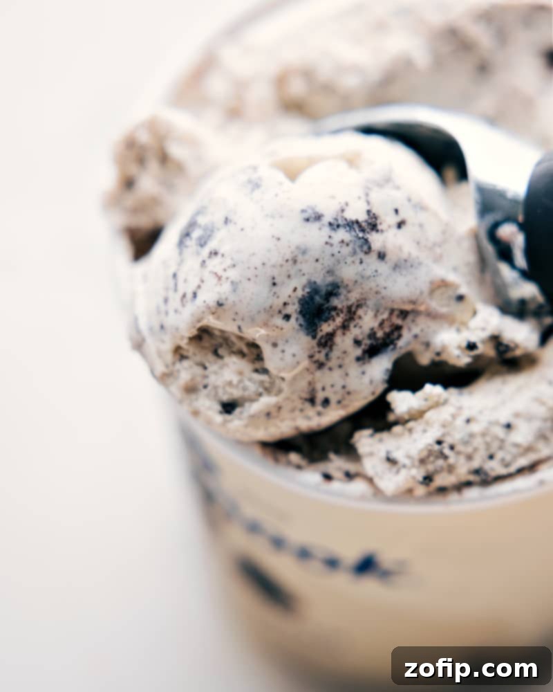 High-quality cookies and cream ice cream is the secret to this delicious Oreo Milkshake. An overhead view of a tub of high-quality cookies and cream ice cream, highlighting its creamy texture and abundant cookie chunks, perfect for making a rich Oreo Milkshake.
