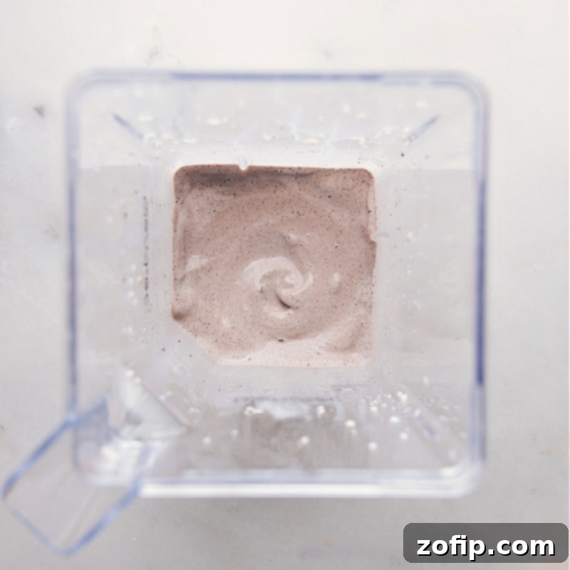 The finished Oreo Milkshake, thick and creamy, ready to be served. A perfectly blended Oreo Milkshake, smooth and thick, poured into a glass and ready for enjoyment, showcasing its rich, dark color and creamy texture.