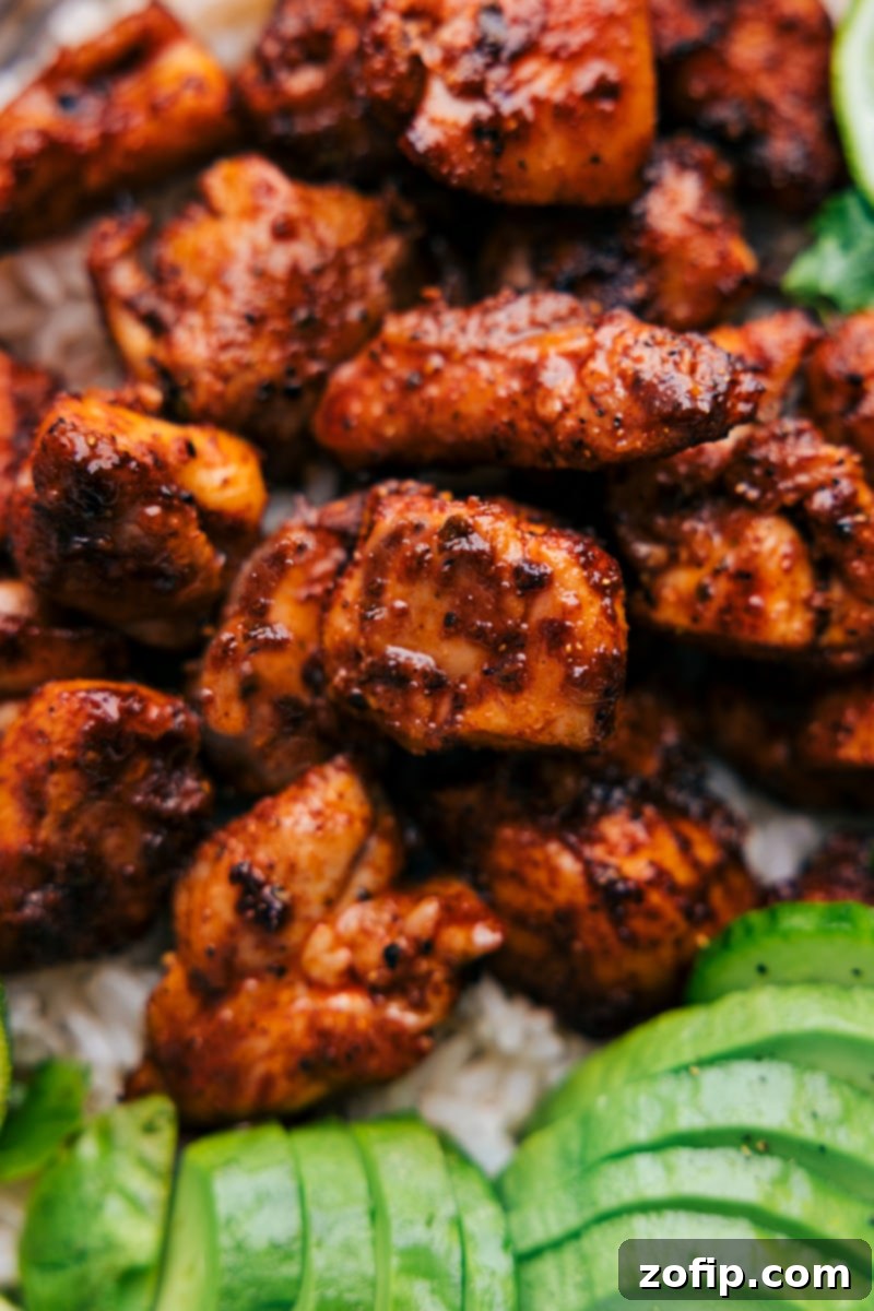 The chicken thighs are coated in a robust seasoning blend, then broiled to achieve a caramelized exterior while keeping the interior tender. It's a versatile recipe, perfect for a quick weeknight meal or incorporated into other dishes like tacos or salads. Recipe via chelseasmessyapron #dinner #quick #easy #simple #familyfriendly #kidfriendly #onepan #healthy #chipotle #chicken Up-close overhead image of the Chipotle Chicken ready to be enjoyed, highlighting the caramelized edges