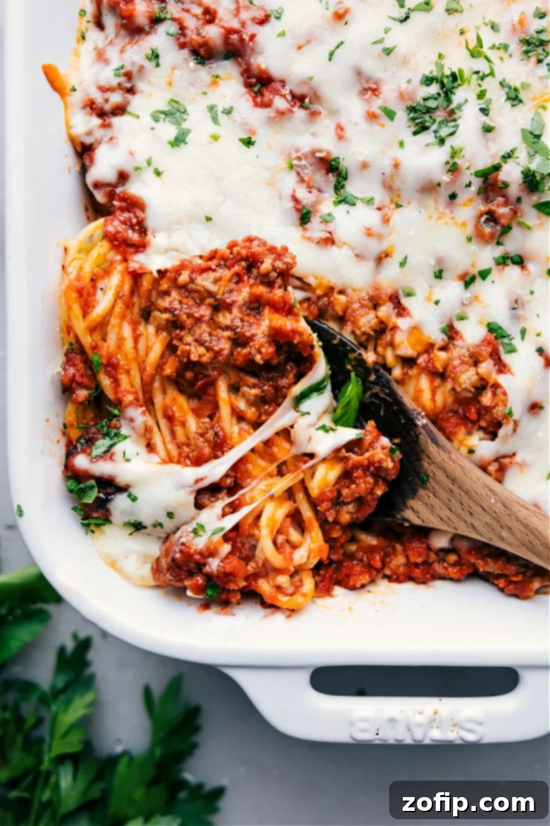 Overhead image of a baked TikTok Spaghetti casserole, showing layers of creamy pasta, rich marinara with Italian sausage, and melted mozzarella and Parmesan cheese.