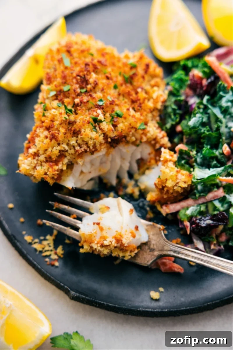 Perfectly baked cod fillet with a golden crispy crust, a fork taking a bite, showcasing the flaky white fish inside, garnished with fresh lemon.