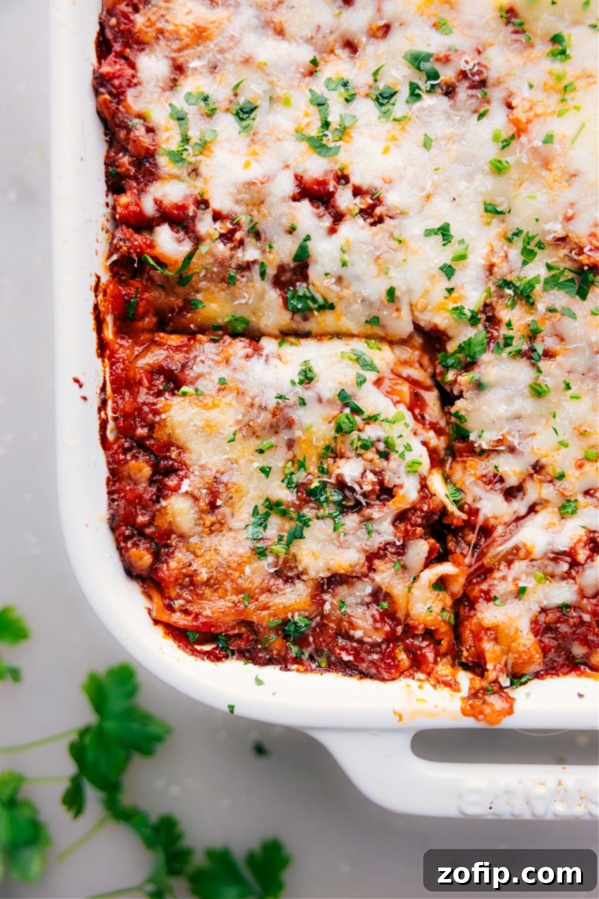 Lasagna in a 9x13 with one piece sliced and ready to be removed