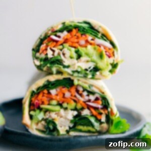 A beautifully assembled Thai Chicken Wrap, sliced in half to reveal the colorful, fresh ingredients inside.