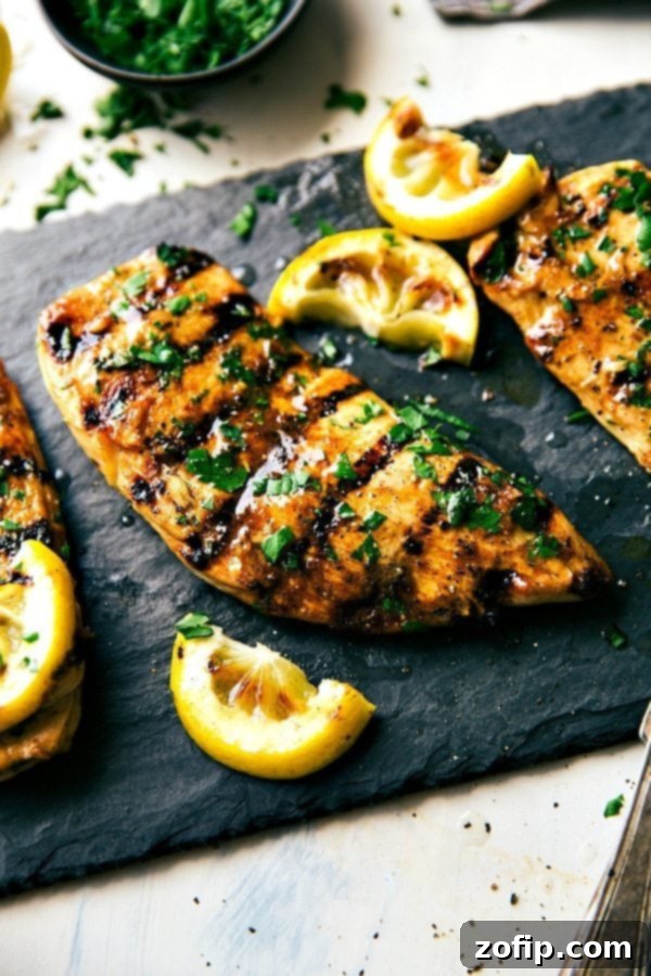 Grilled Chicken Marinade with Fresh Herbs and Lemon Juice The best grilled chicken marinade, garnished with fresh herbs on top and lemon juice ready to be cut up and enjoyed for added flavor.