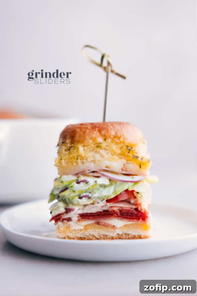 Delicious Grinder Sliders on a platter, ready to be served and enjoyed, showcasing the melted cheese and fresh slaw topping.
