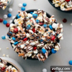 A vibrant close-up of 4th of July Popcorn, showcasing the red, white, and blue M&M's and white chocolate coating.