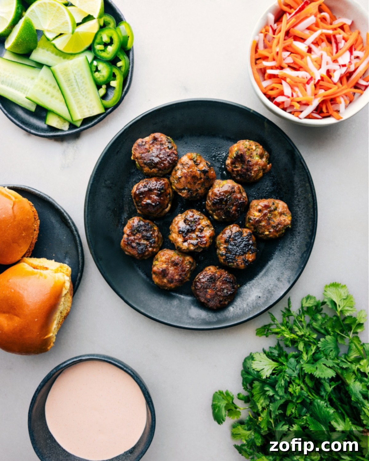 Pristine pork Banh Mi Meatballs amid the assembly ingredients Perfectly baked pork banh mi meatballs presented amid an array of fresh ingredients, poised for slider assembly.