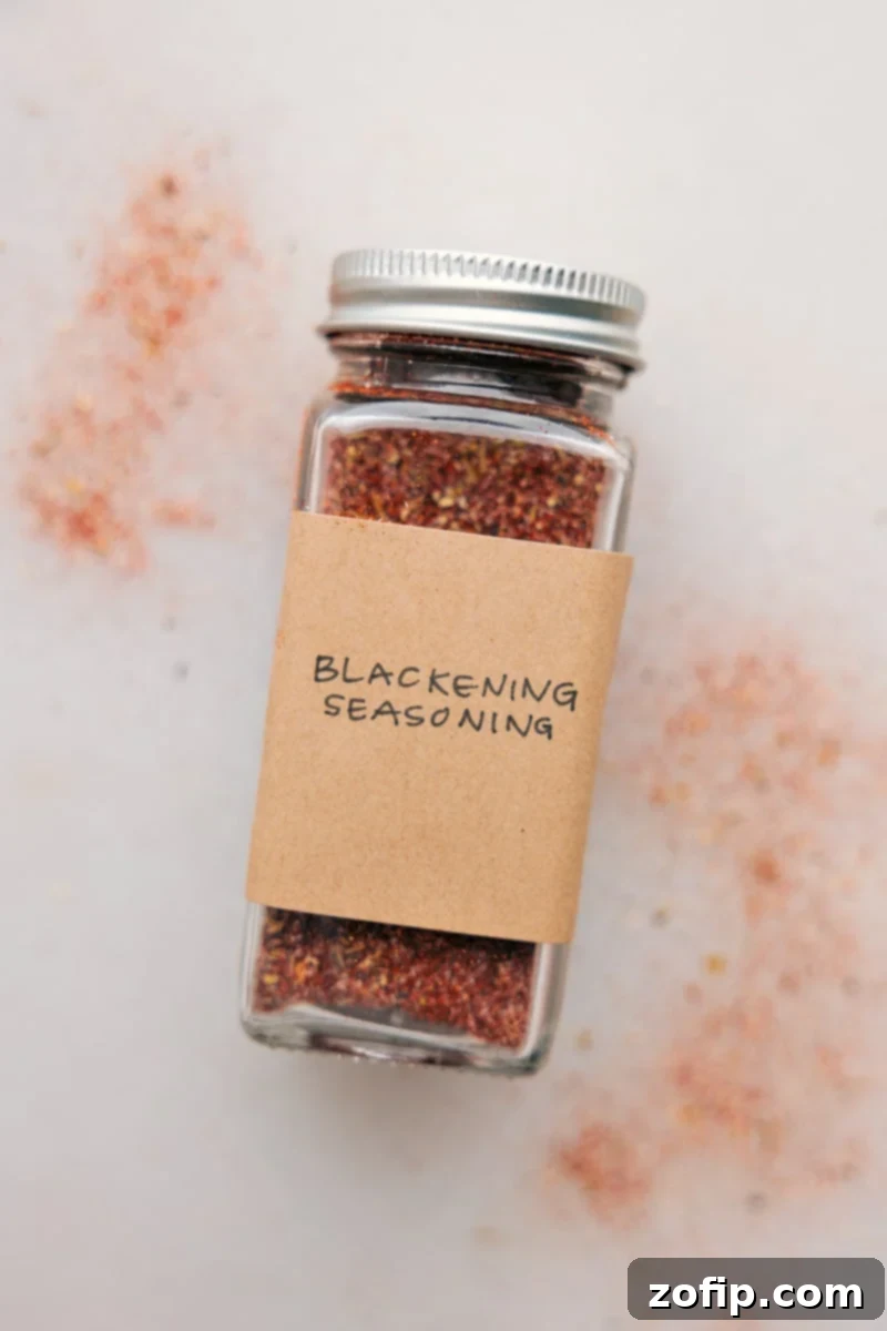 This Blackening Seasoning recipe creates a versatile, smoky, and spicy blend perfect for forming a flavorful crust on grilled or pan-fried dishes. Easily homemade, it combines everyday spices and can be stored for future use, bringing a robust flavor to meats, fish, and vegetables. Recipe via chelseasmessyapron #spice #seasonings #quick #easy #simple #grilling #blackening #seasoning Image of the freshly made blackened seasoning in an airtight container, ready for use.
