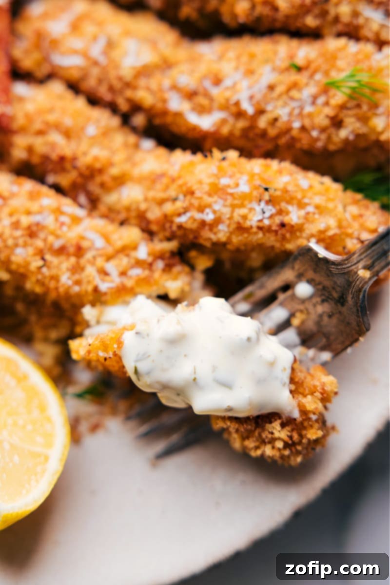 Delicious and healthy baked fish and chips ready to be served. Up close overhead image of the Baked Fish and Chips ready to be enjoyed, garnished with lemon and fresh parsley.