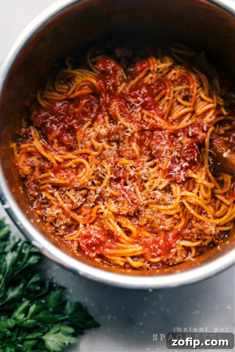 Overhead view of Instant Pot Spaghetti with Italian sausage and marinara, garnished with Parmesan and parsley