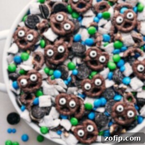 A bowl of Goblin Goodies (Halloween Muddy Buddies) with various Halloween-themed decorations around it.