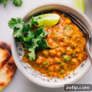 A bowl of creamy pumpkin curry, garnished with fresh cilantro, ready to be served.