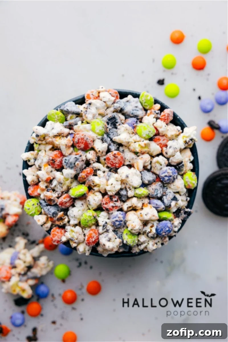 Overhead view of a bowl of Halloween Popcorn, a festive mix of popcorn, white chocolate, M&M's, and Oreos