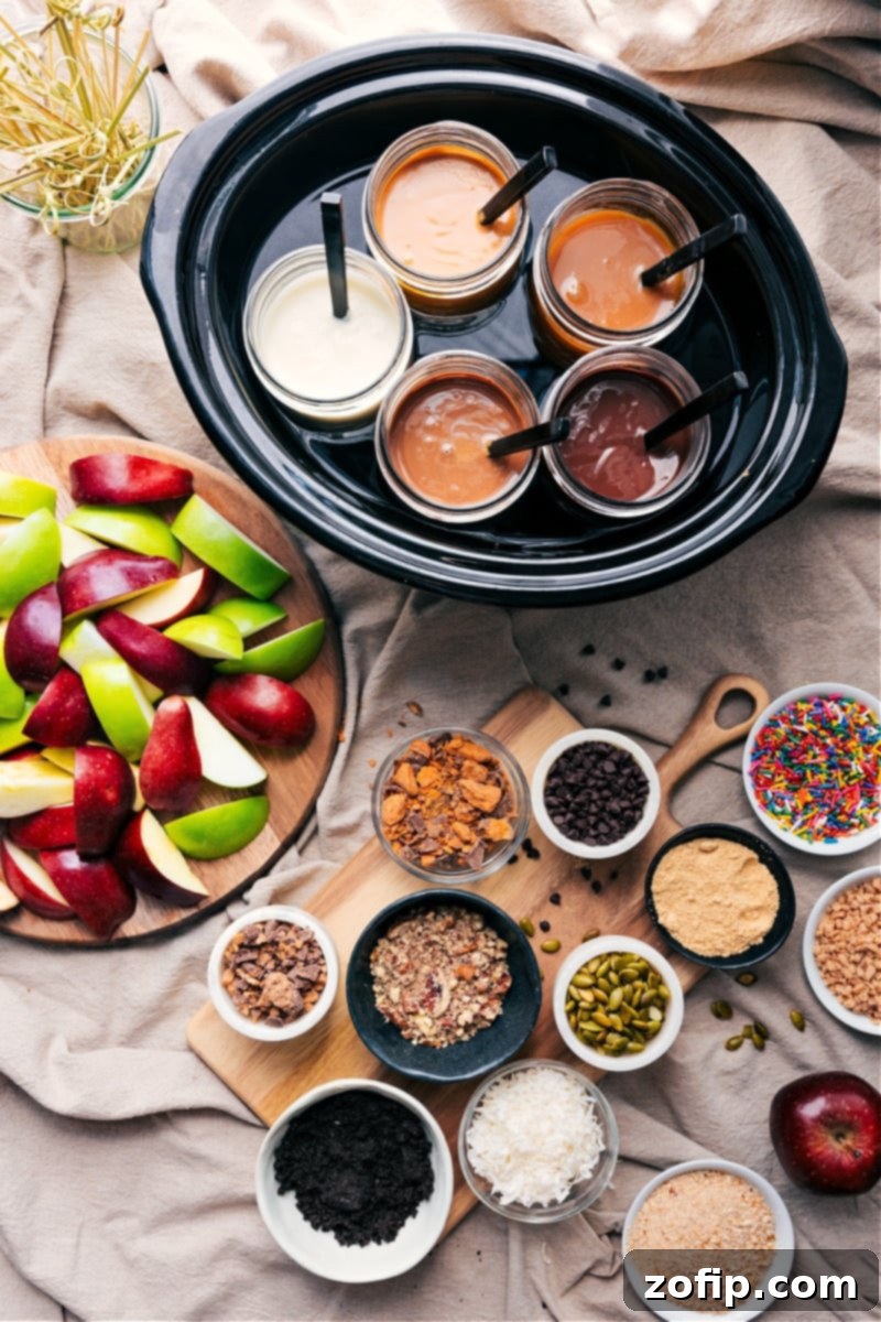 Overhead image of a vibrant and inviting caramel apple bar spread, showcasing various dips, colorful toppings, and freshly sliced apples ready for dipping.