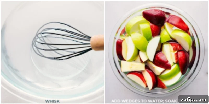 Close-up shot of freshly sliced apples soaking in a bowl of saltwater, a crucial step for preventing browning.