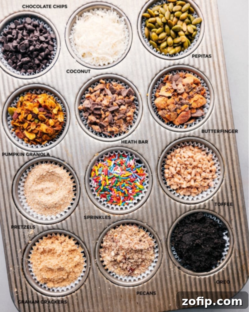 An organized display of various caramel apple bar toppings laid out in muffin tins with liners, showcasing colorful and textured options.