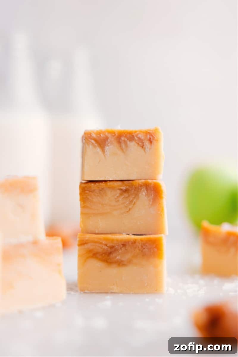 Three pieces of Homemade Caramel Apple Fudge stacked, showcasing the creamy texture and caramel swirl.