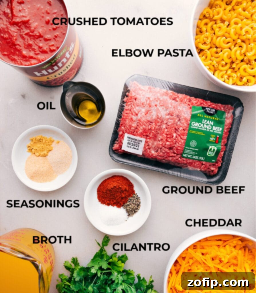 Fresh ingredients laid out for homemade Hamburger Helper, including ground beef, pasta, cheese, and spices.