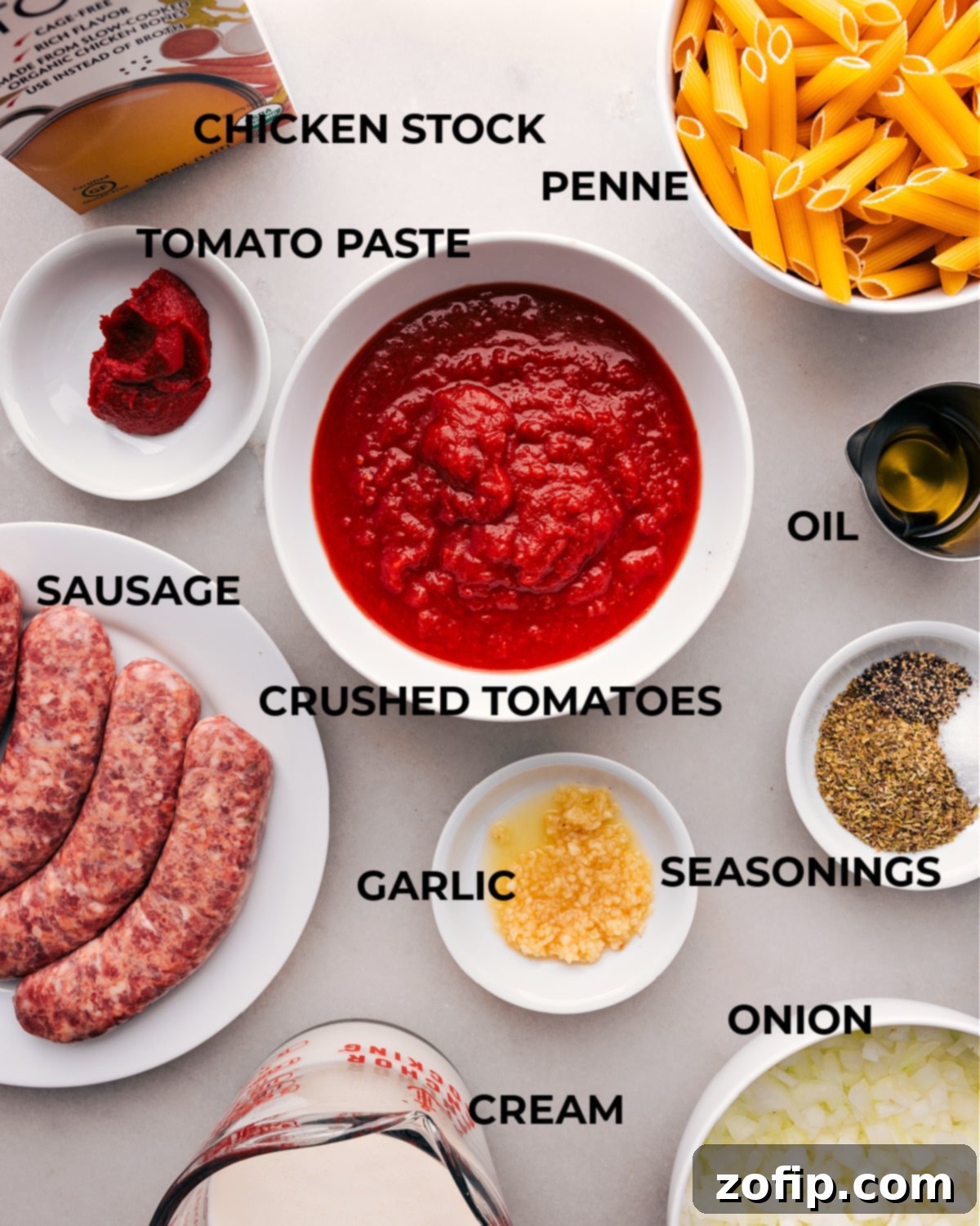 All Ingredients for the Recipe Gathered Together. A collection of fresh ingredients for the penne pasta dish, including sausage, tomatoes, cream, and herbs, neatly arranged on a countertop.