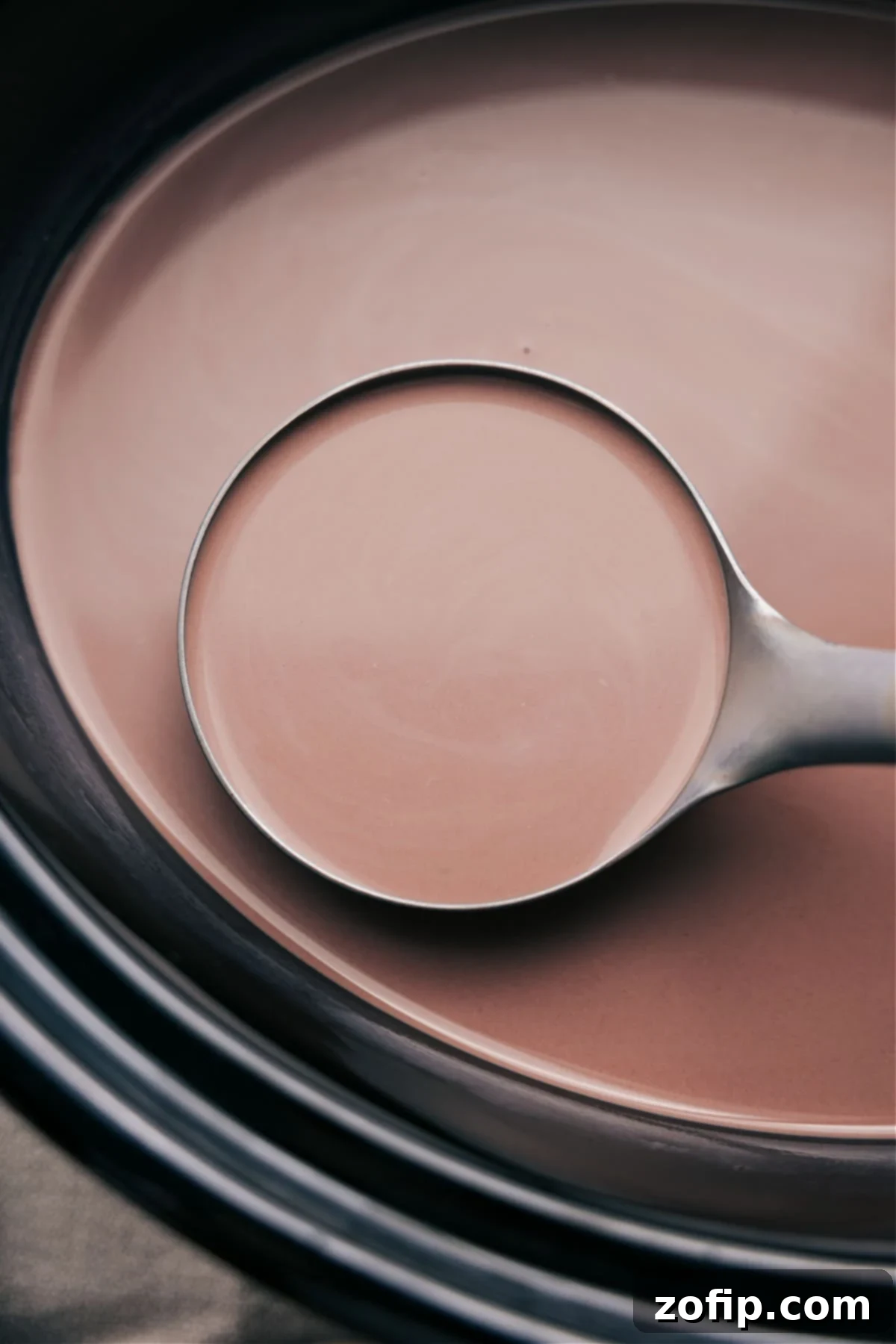 A spoonful of the warm beverage, poised and ready to be poured into a waiting mug, promising a comforting experience.