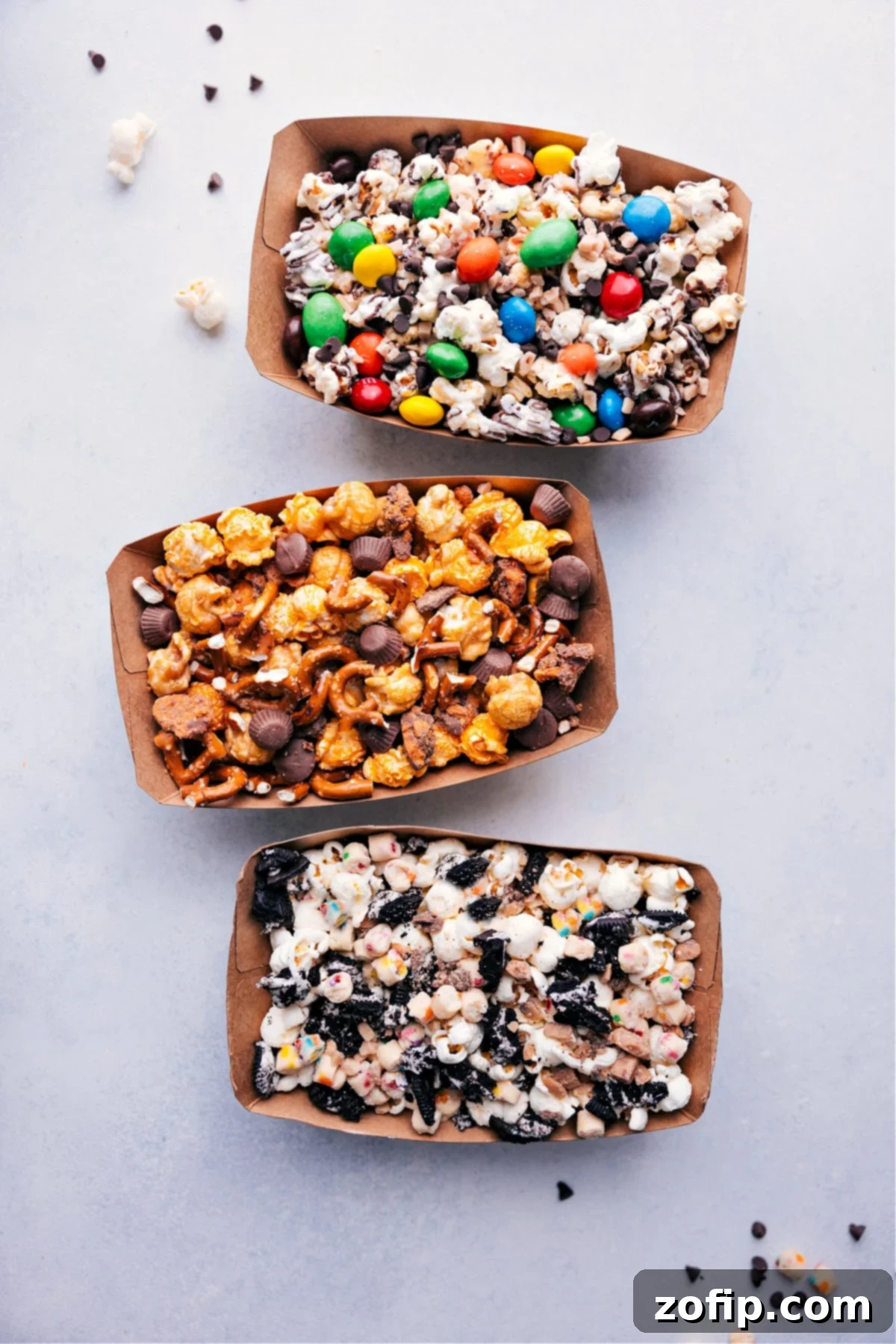 Three neatly arranged containers filled with delightful popcorn and various toppings, ready for guests to enjoy.