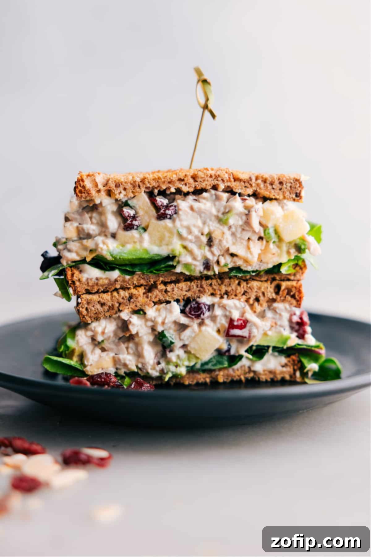 Stacked half-cut chicken salad with apples sandwich, showcasing the flavorful filling inside a golden croissant.
