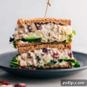 Stacked half-cut chicken salad with apples, showcasing the flavorful filling inside.