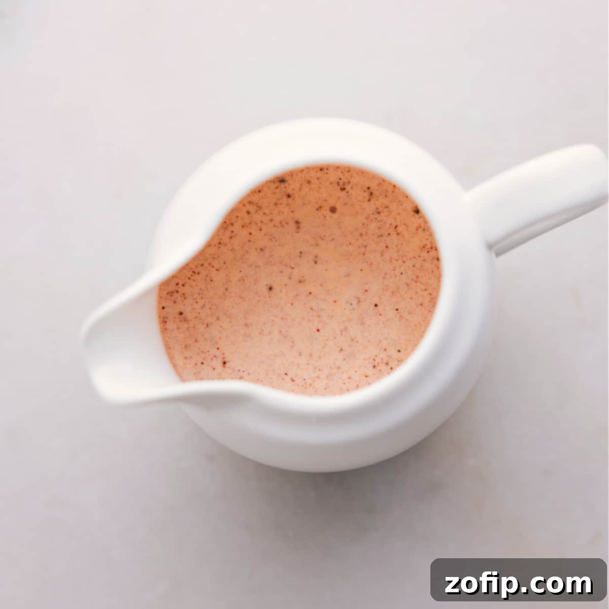 How To Dress Mexican Street Corn Pasta Salad A close-up shot of the creamy chili-lime dressing being generously drizzled from a glass jar onto a large, colorful bowl of assembled Mexican Street Corn Pasta Salad, making it look incredibly appealing.