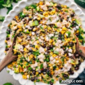 Fiesta Elote Pasta Salad 2 A top-down shot of a single serving of Mexican Street Corn Pasta Salad in a white bowl, showing off the vibrant colors and creamy texture, with a spoon ready to dig in and enjoy.