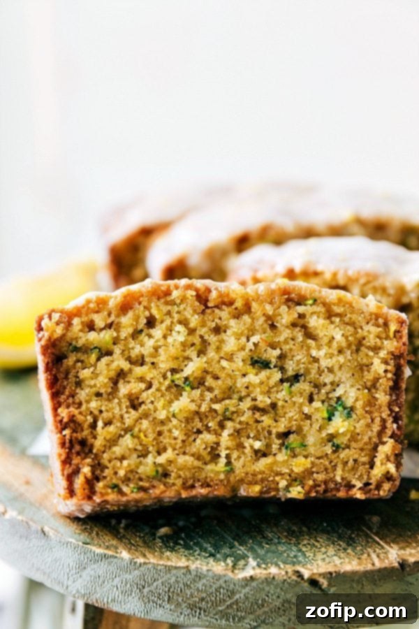 A perfectly baked and glazed slice of moist lemon zucchini bread, ready to be savored.