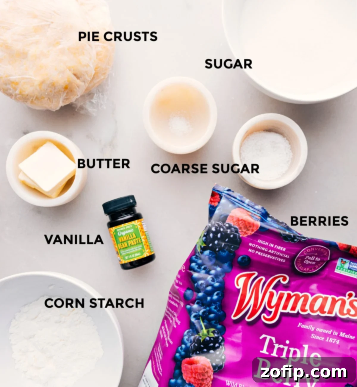 Berry Pie Ingredients All the fresh ingredients laid out on a wooden board, including mixed berries, granulated sugar, fresh lemon, unsalted butter, and cornstarch, for crafting this delicious dessert.
