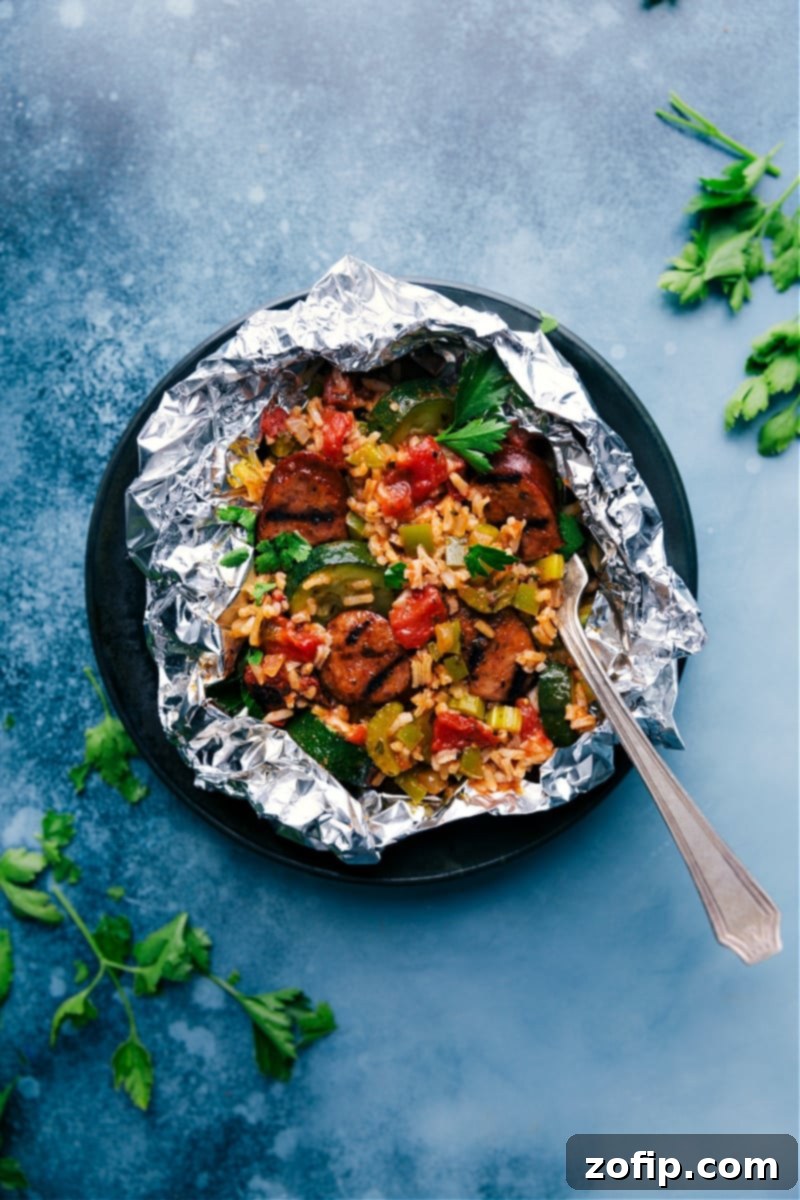 Tin Foil Jambalaya ready to eat, served in an open foil packet with fresh parsley garnish