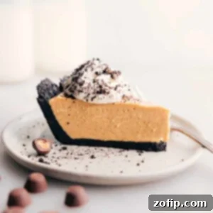 Decadent Peanut Butter Dream 2 Classic Peanut Butter Pie with a perfect slice removed, topped with whipped cream and crushed Oreos