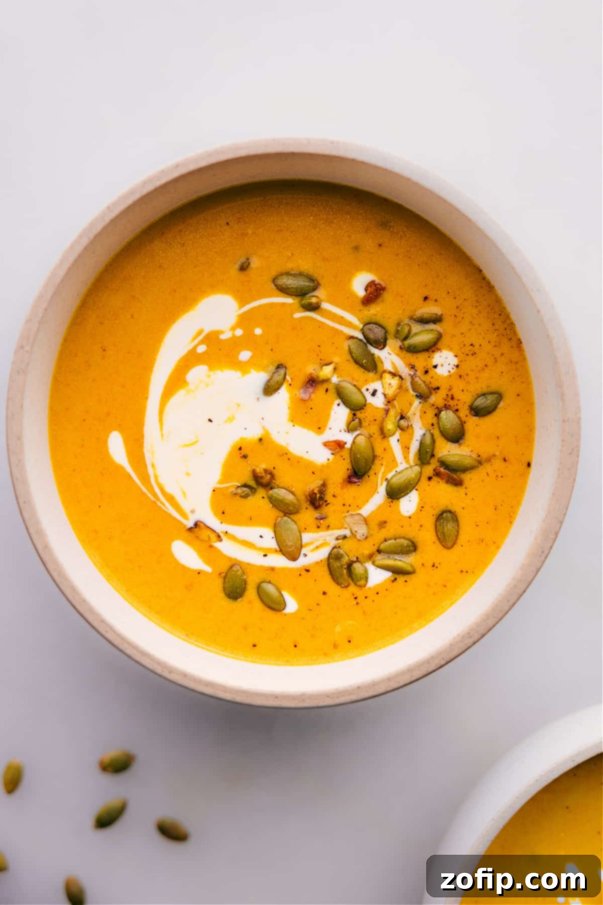 The Best Curry Pumpkin Soup A steaming bowl of vibrant Pumpkin Curry Soup, garnished and ready to be enjoyed.