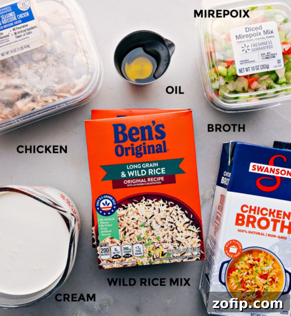 A vibrant selection of fresh ingredients, including mirepoix vegetables, wild rice blend, chicken broth, heavy cream, and cooked chicken, laid out neatly on a kitchen counter, showcasing the simple components required for this quick and easy weeknight dinner.