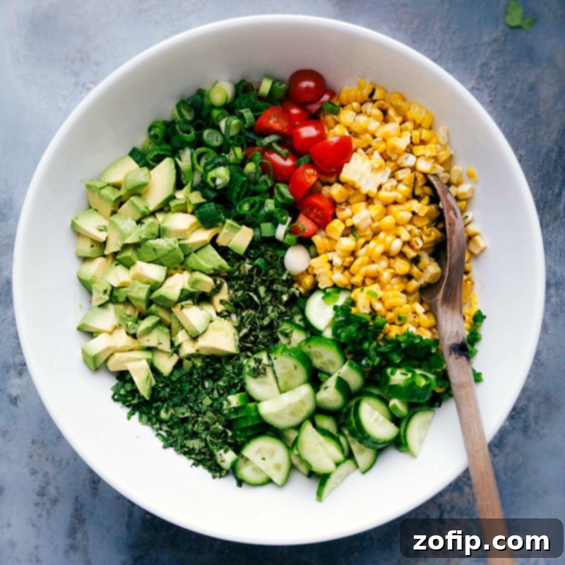 Preparation Phase: All Components of the Corn Salad Recipe in a Bowl Ingredients for the corn salad recipe in a bowl, including corn, tomatoes, onions, and herbs, ready for mixing.