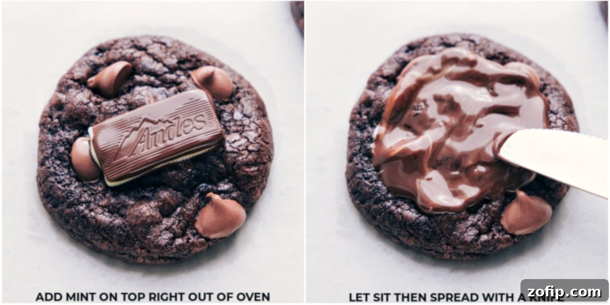 A freshly baked chocolate cookie with a melted Andes mint being gently spread across the top using a butter knife, creating a smooth, minty chocolate layer.