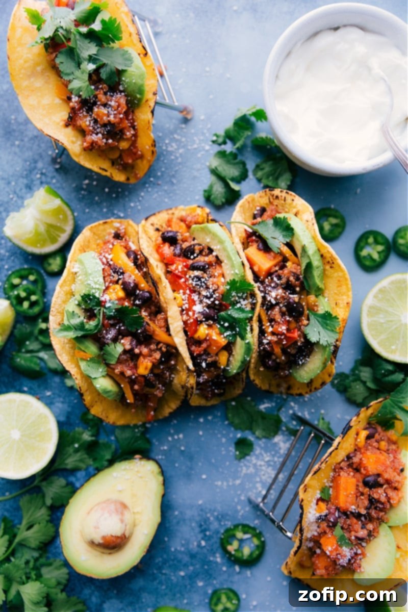 Overhead shot of vibrant Slow Cooker Quinoa Fajitas, featuring shredded chicken, colorful vegetables, and quinoa, expertly wrapped in warm tortillas and garnished with fresh cilantro and lime, ready for a healthy and easy dinner.