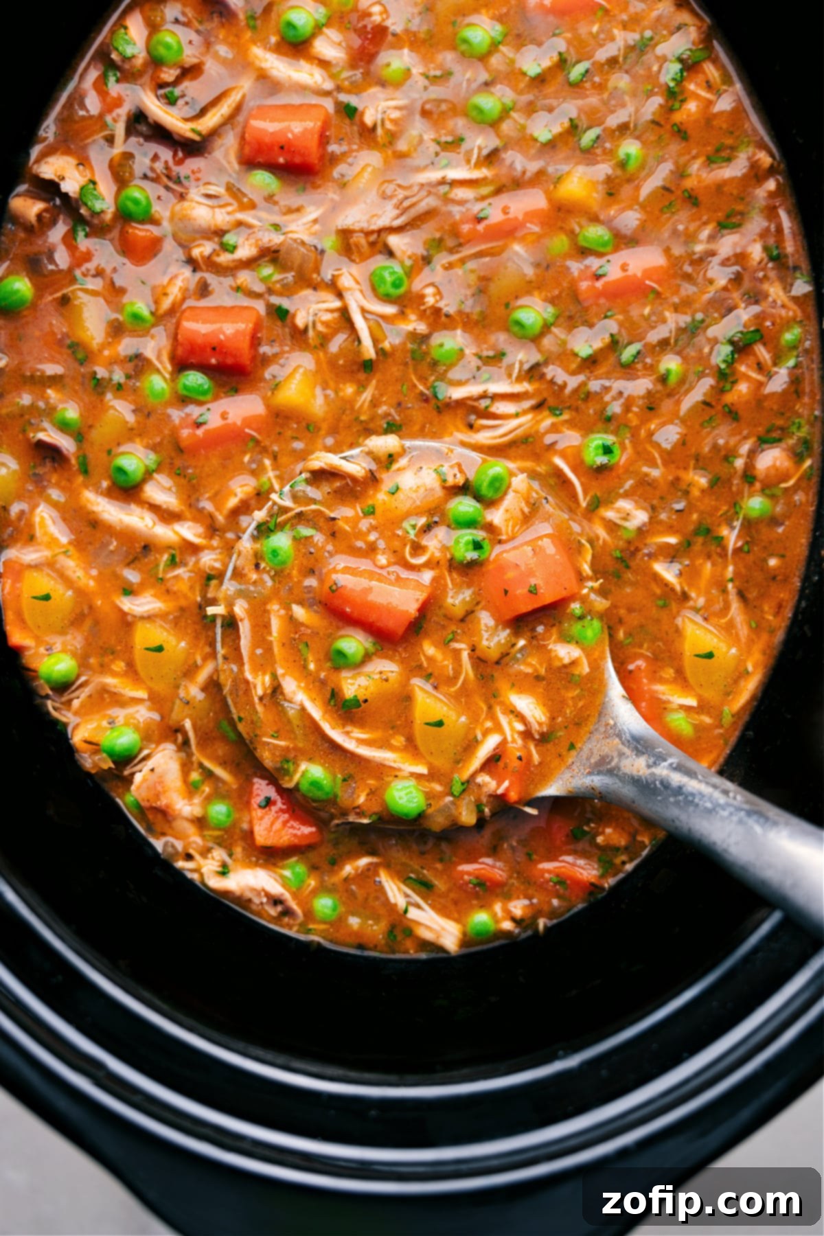 The Best Crockpot Chicken Stew Crockpot Chicken Stew in the crockpot with a big label full coming out.