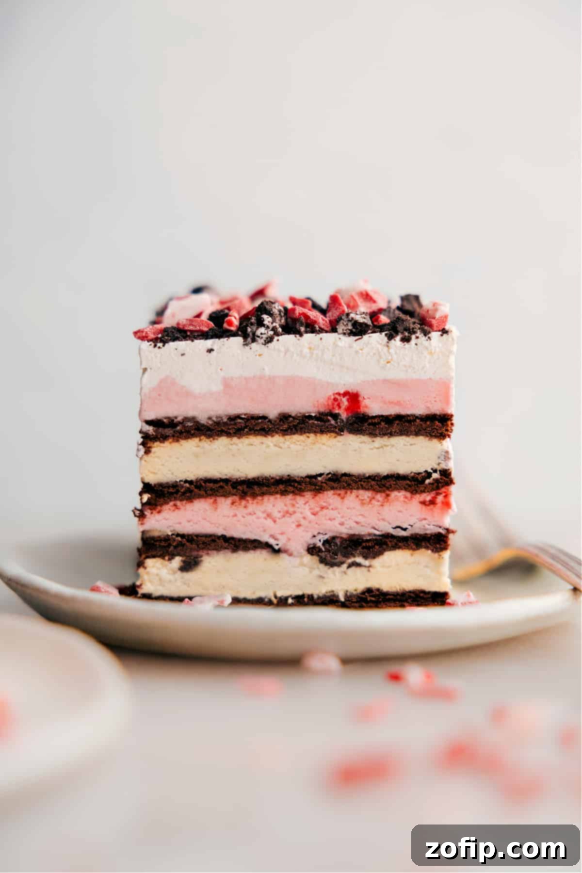 Delicious Slice of Peppermint Ice Cream Bar Layers A beautifully sliced Peppermint Ice Cream Bar, showcasing distinct layers of chocolate ice cream sandwich, creamy peppermint ice cream, and a fluffy white topping, ready to be enjoyed.
