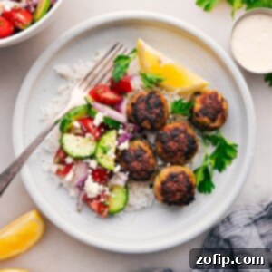 A plate of Greek Turkey Meatballs with feta sauce and a side salad.