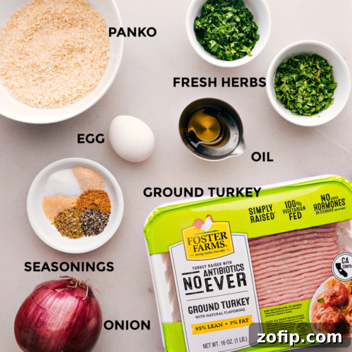 All the fresh ingredients for Greek Turkey Meatballs and Feta Sauce laid out and prepped on a kitchen counter, ready for mixing and cooking.