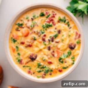 A vibrant close-up of the finished Creamy Italian Sausage Pasta Soup, garnished and ready to serve.
