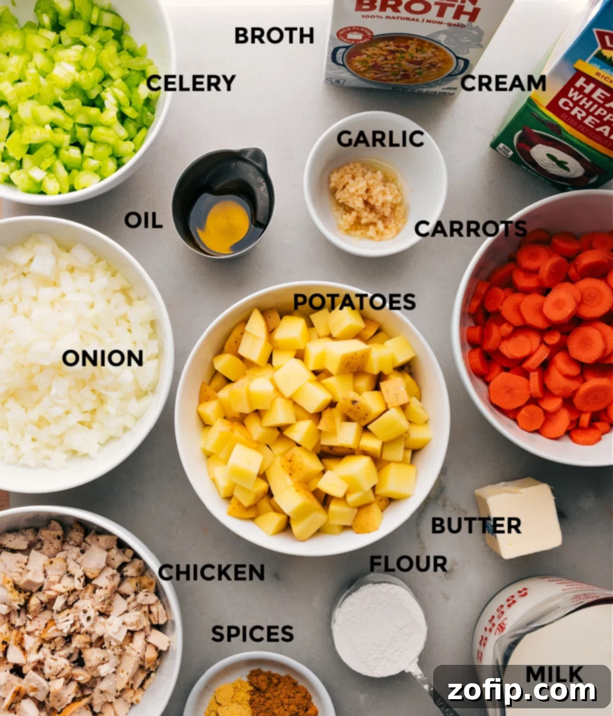 Essential Ingredients for a Flavorful Curry Chicken Chowder A vibrant selection of fresh ingredients carefully laid out on a rustic wooden surface, highlighting essential components like precisely diced golden potatoes, aromatic chopped yellow onions, thinly sliced carrots and celery, fresh garlic cloves, and an array of aromatic spices including a prominent bowl of rich yellow curry powder. These are all perfectly arranged and ready to be incorporated into the delicious homemade Curry Chicken Chowder.
