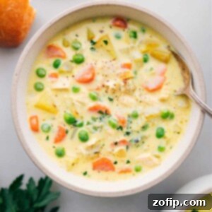 Fragrant Curry Chicken Chowder 2 A beautifully garnished bowl of creamy Curry Chicken Chowder, ready to be enjoyed, served alongside warm bread.