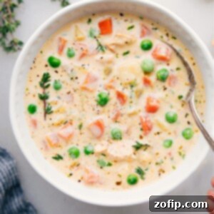 A hearty serving of creamy chicken and potato soup in a rustic bowl, garnished with fresh herbs.